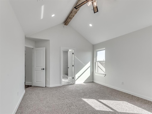 empty room featuring lofted ceiling with beams, ceiling fan, and carpet floors