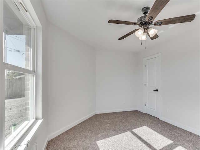 spare room with light carpet, a wealth of natural light, and ceiling fan