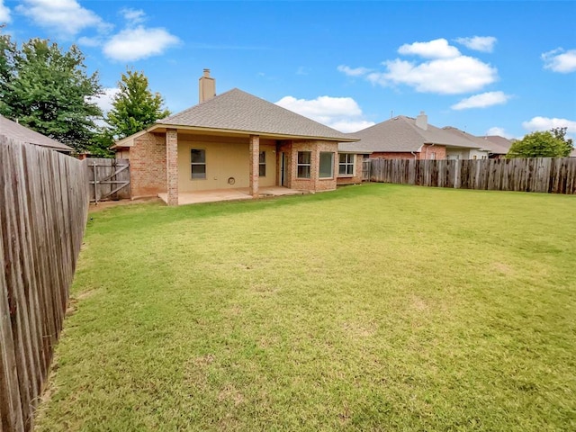 back of property with a patio and a lawn