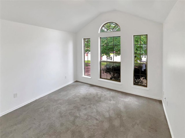 carpeted empty room with lofted ceiling