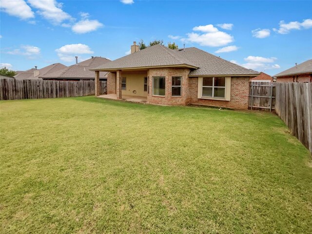 back of house featuring a patio and a lawn