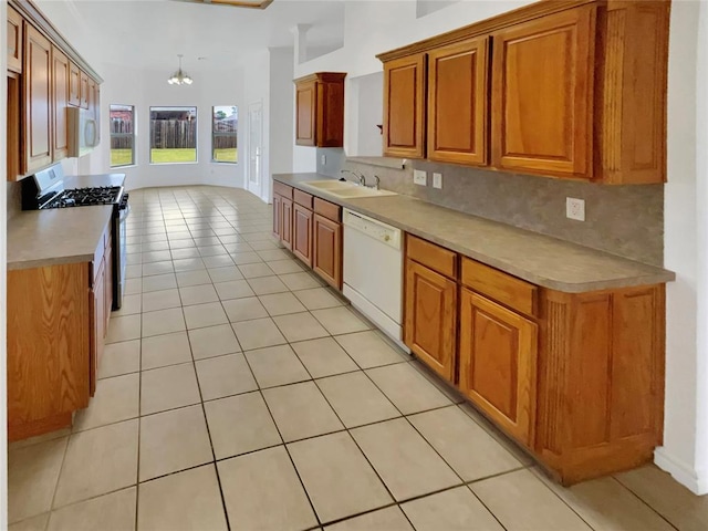 kitchen with white appliances, tasteful backsplash, a notable chandelier, and sink