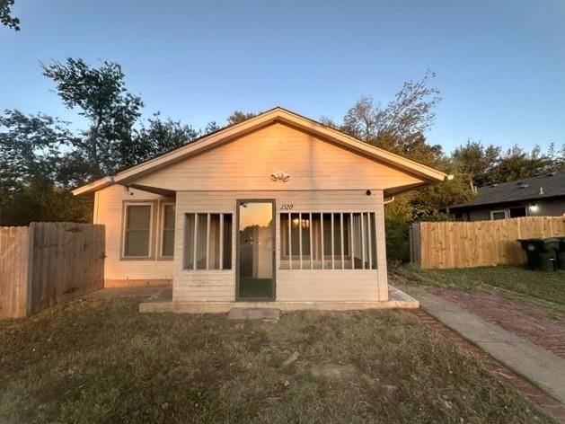 rear view of property featuring a lawn