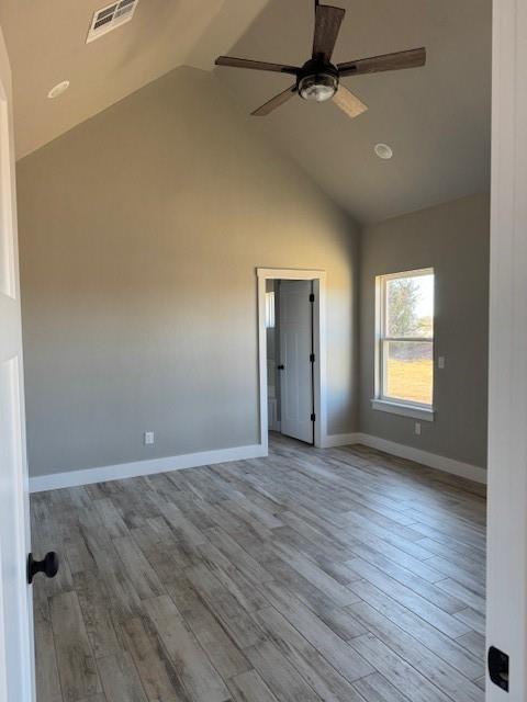 unfurnished room with light wood-type flooring, vaulted ceiling, and ceiling fan