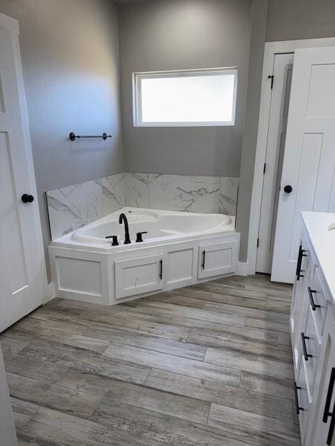 bathroom with vanity, hardwood / wood-style flooring, and a bathing tub