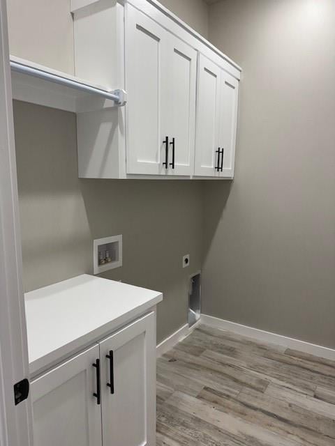 clothes washing area featuring washer hookup, cabinets, hookup for an electric dryer, and light wood-type flooring