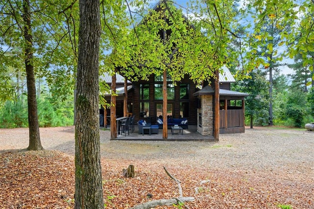 rear view of property with an outdoor hangout area and a patio area