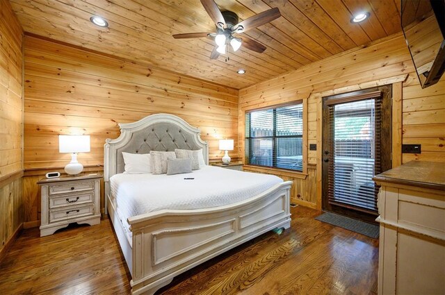 bedroom with wooden walls, ceiling fan, and hardwood / wood-style flooring