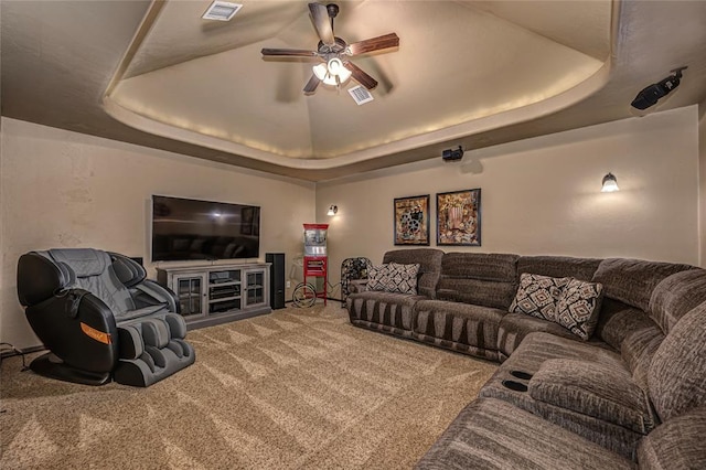 carpeted cinema featuring ceiling fan and a raised ceiling