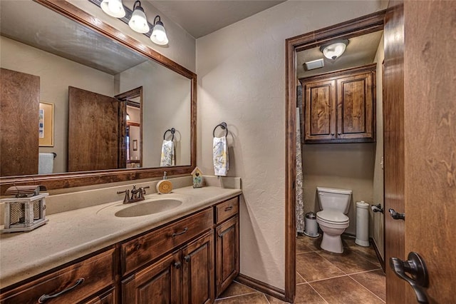 bathroom with tile patterned flooring, vanity, and toilet