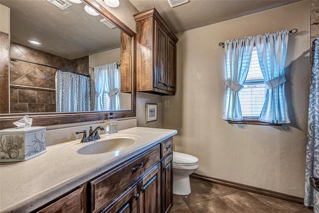 bathroom with curtained shower, tile patterned flooring, vanity, and toilet