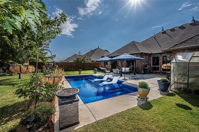 view of pool with a lawn and a patio area