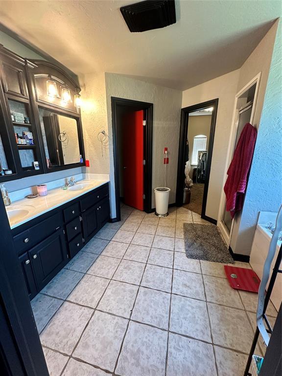 16355 Cobblestone Cir, Choctaw, OK 73020 - full bath with a textured wall, double vanity, tile patterned floors, a garden tub, and a stall shower