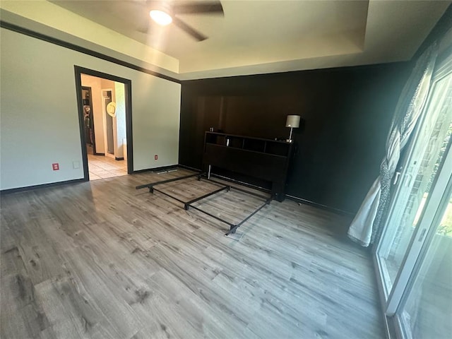 16355 Cobblestone Cir, Choctaw, OK 73020 - bedroom featuring wood finished floors, a raised ceiling, multiple windows, and a ceiling fan