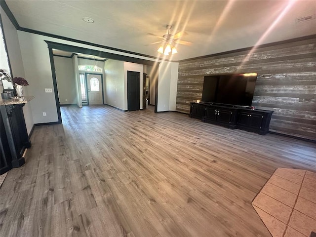 16355 Cobblestone Cir, Choctaw, OK 73020 - living room with wooden walls, a ceiling fan, light wood-type flooring, and crown molding