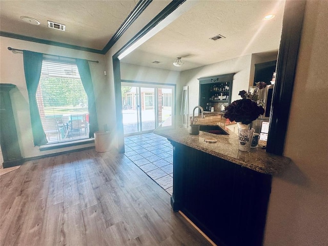 16355 Cobblestone Cir, Choctaw, OK 73020 - kitchen with wood finished floors, a textured ceiling, and stone counters