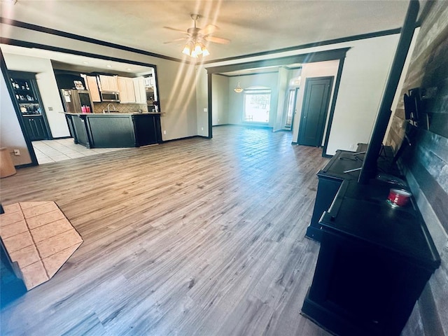 16355 Cobblestone Cir, Choctaw, OK 73020 - unfurnished living room featuring a ceiling fan, light wood-style floors, and crown molding