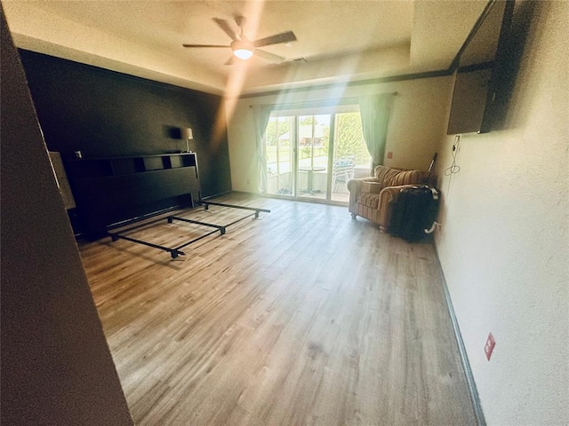16355 Cobblestone Cir, Choctaw, OK 73020 - living area featuring wood finished floors, a ceiling fan, a textured wall, a tray ceiling, and a textured ceiling