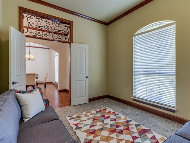 living room featuring crown molding, light carpet, and an inviting chandelier