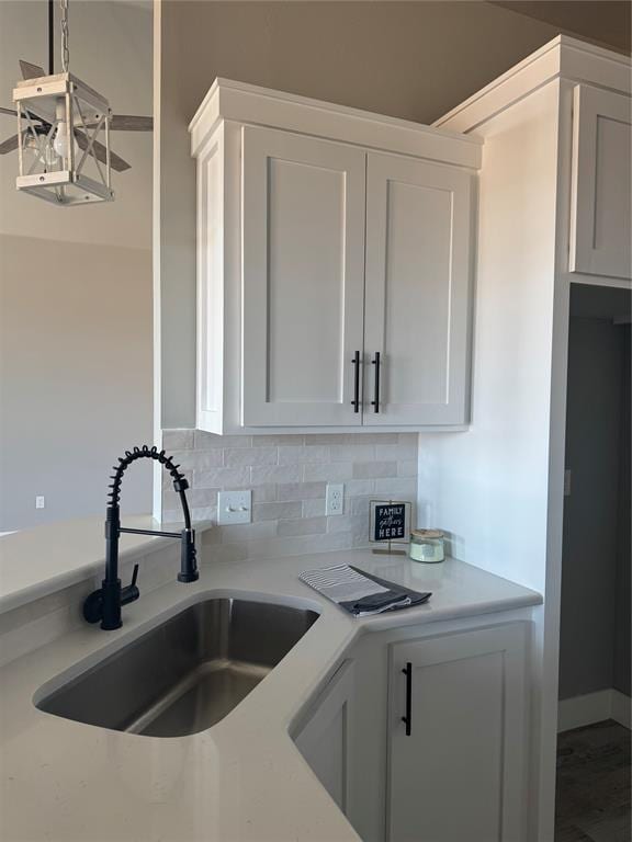 kitchen featuring light countertops, white cabinetry, and a sink