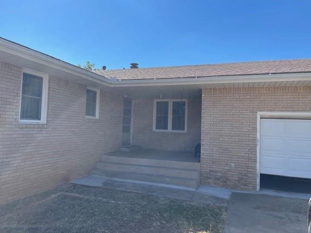 doorway to property with covered porch and a garage