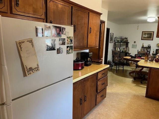 kitchen with light carpet, white refrigerator, and built in desk