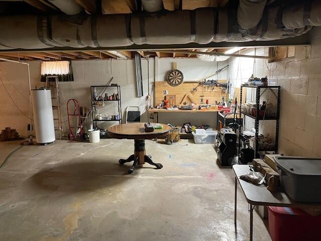 basement featuring a workshop area and water heater