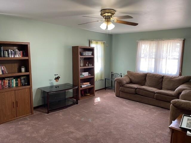 carpeted living room with ceiling fan