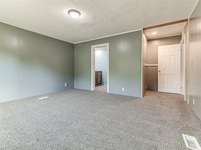 empty room with crown molding, light colored carpet, and a textured ceiling