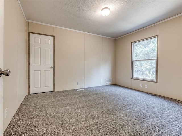 carpeted empty room featuring a textured ceiling and ornamental molding