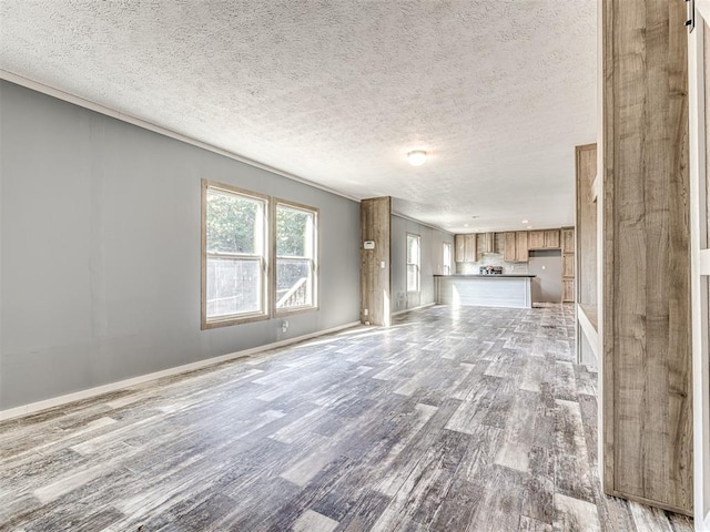 unfurnished living room featuring hardwood / wood-style flooring and a textured ceiling