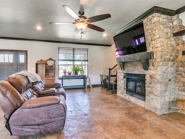 living room with crown molding, ceiling fan, a healthy amount of sunlight, and a stone fireplace