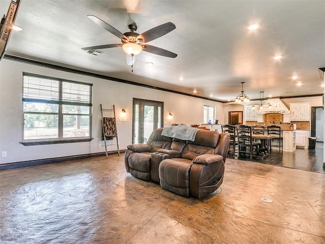 living room with ceiling fan and ornamental molding