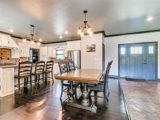 dining space featuring dark wood-type flooring, crown molding, and an inviting chandelier