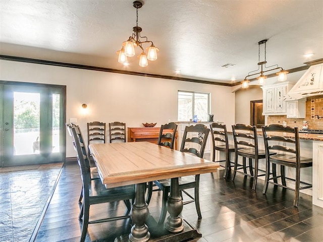 dining room featuring an inviting chandelier, a healthy amount of sunlight, dark hardwood / wood-style floors, and ornamental molding