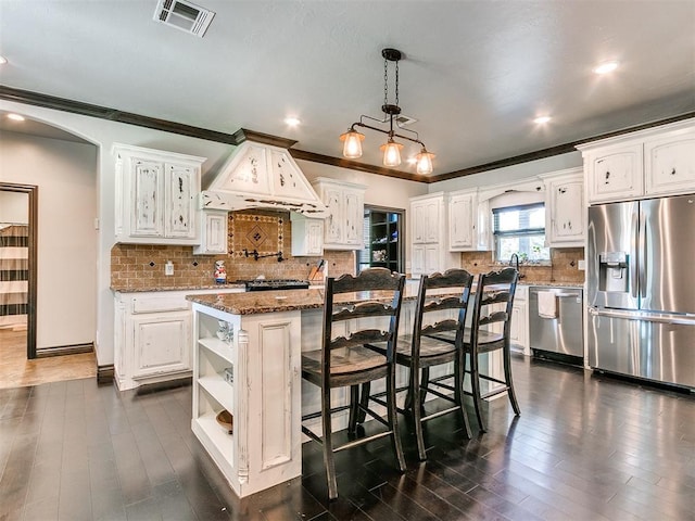 kitchen with white cabinets, a center island, custom range hood, and stainless steel appliances