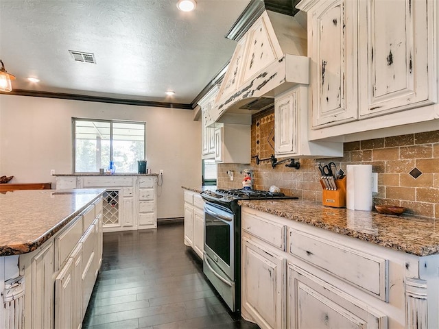 kitchen with tasteful backsplash, stainless steel gas range oven, light stone counters, dark hardwood / wood-style floors, and ornamental molding