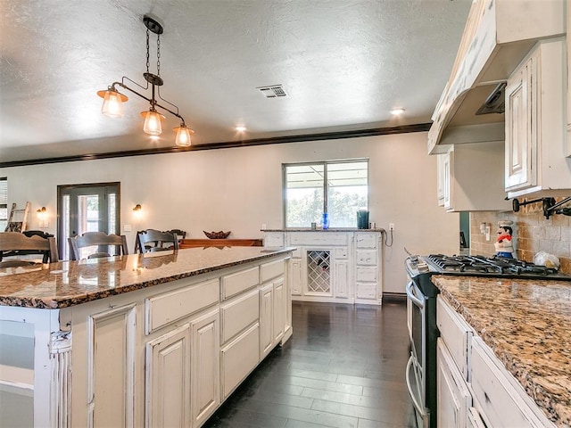 kitchen featuring gas range, white cabinetry, and light stone counters