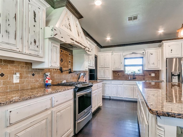 kitchen with stainless steel appliances, white cabinetry, tasteful backsplash, and ornamental molding