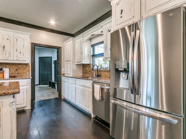 kitchen featuring stone counters, white cabinets, crown molding, sink, and stainless steel appliances