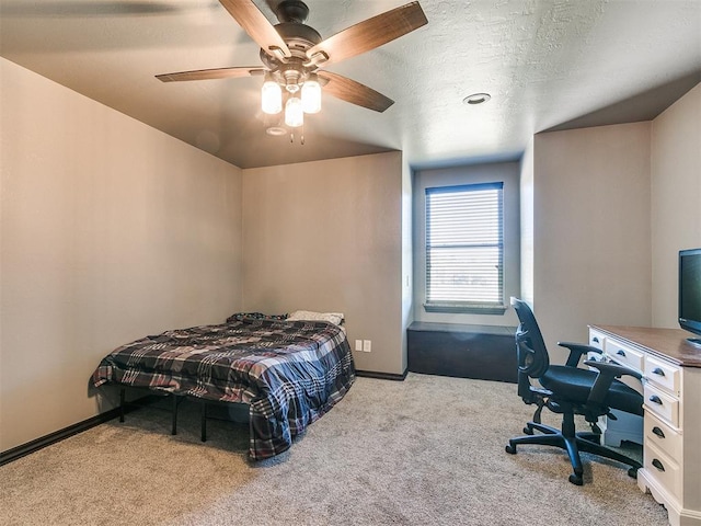 carpeted bedroom featuring a textured ceiling and ceiling fan