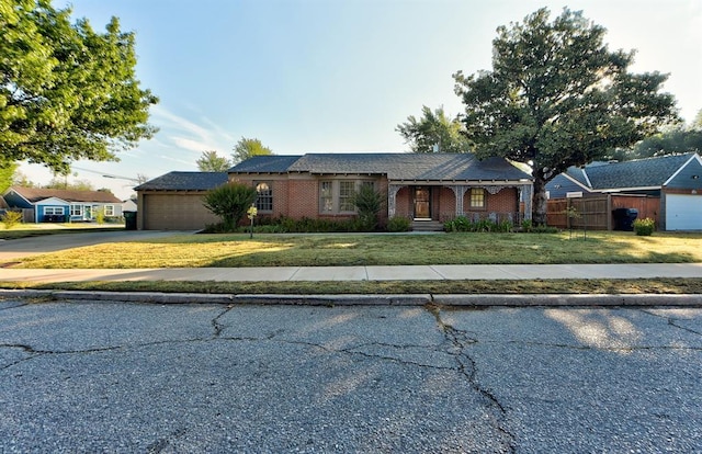 single story home featuring a front lawn and a garage