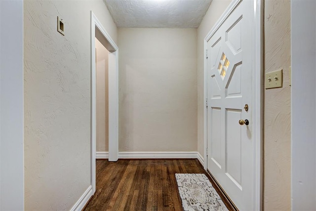 hall featuring dark hardwood / wood-style floors and a textured ceiling