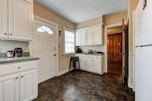 kitchen with white cabinets and white fridge