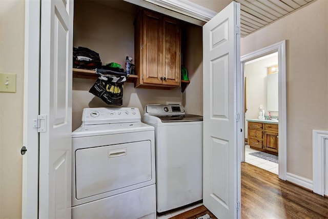 laundry room with dark hardwood / wood-style floors, cabinets, and washing machine and clothes dryer