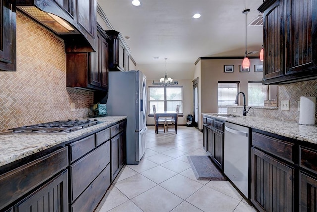 kitchen featuring light stone countertops, hanging light fixtures, tasteful backsplash, a notable chandelier, and appliances with stainless steel finishes