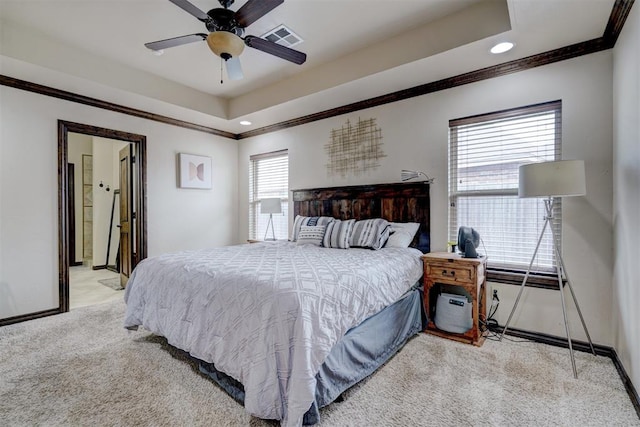 bedroom featuring ceiling fan, crown molding, light carpet, and a tray ceiling