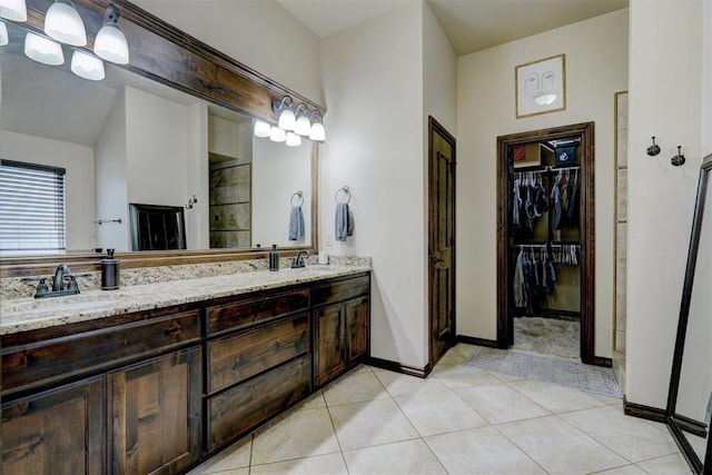 bathroom with tile patterned flooring, vanity, and vaulted ceiling