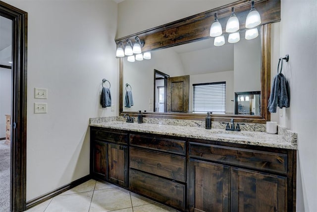 bathroom with tile patterned flooring, vanity, and vaulted ceiling