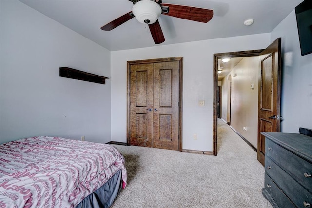 carpeted bedroom with ceiling fan and a closet